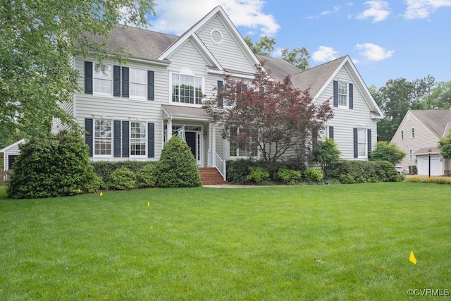 view of front of house with a front yard and roof with shingles