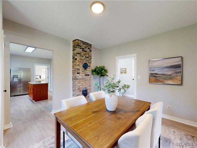 56 Mancha Ave, Claremont, VA 23899 - dining room featuring light wood finished floors and a fireplace