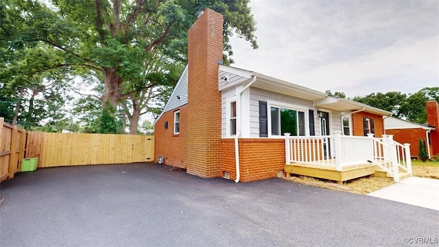 8803 Dena Dr, Henrico, VA 23229 - view of front of house with a chimney, fence, brick siding, and a wooden deck