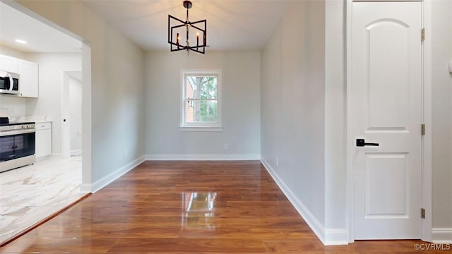 8803 Dena Dr, Henrico, VA 23229 - unfurnished dining area with a chandelier, baseboards, and light wood-style flooring