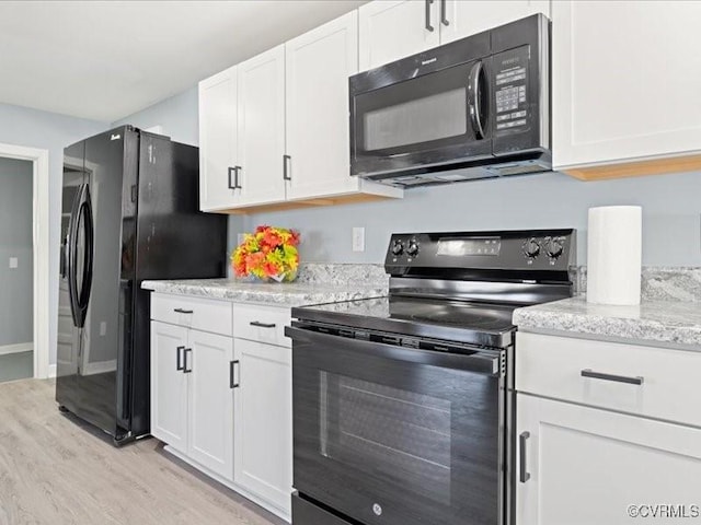 2519 Deerfield Dr, Petersburg, VA 23805 - kitchen with black appliances, light wood-type flooring, white cabinetry, and light stone counters