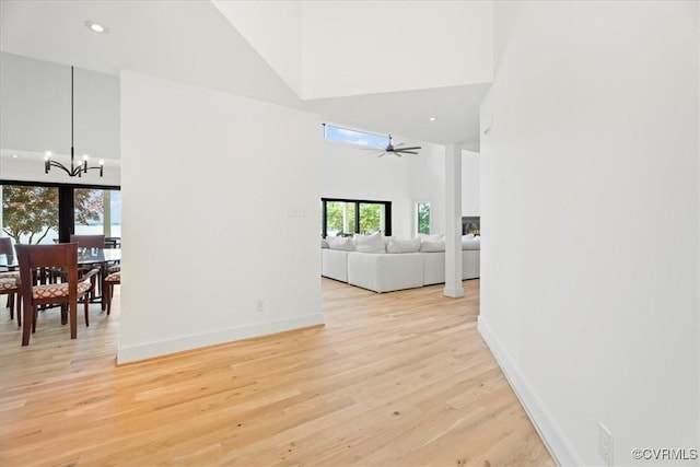 1665 Wilton Creek Rd, Hartfield, VA 23071 - living area with a towering ceiling, a chandelier, light wood finished floors, ceiling fan, and baseboards