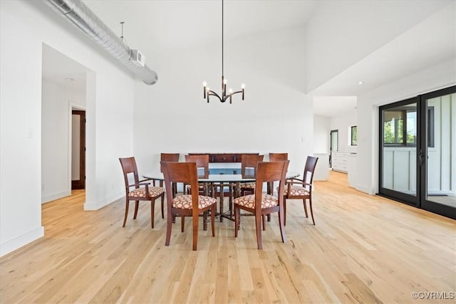 1665 Wilton Creek Rd, Hartfield, VA 23071 - dining area with light wood finished floors, a chandelier, a high ceiling, and baseboards