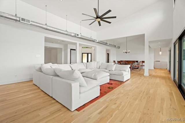 1665 Wilton Creek Rd, Hartfield, VA 23071 - living room with light wood-type flooring, a towering ceiling, a ceiling fan, baseboards, and healthy amount of natural light