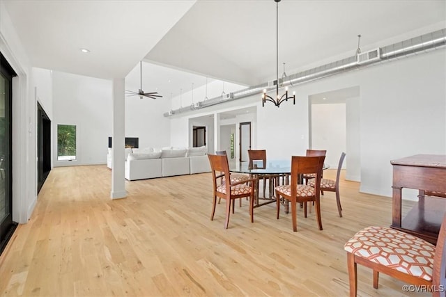 1665 Wilton Creek Rd, Hartfield, VA 23071 - dining area with light wood-type flooring, a chandelier, a ceiling fan, a high ceiling, and baseboards