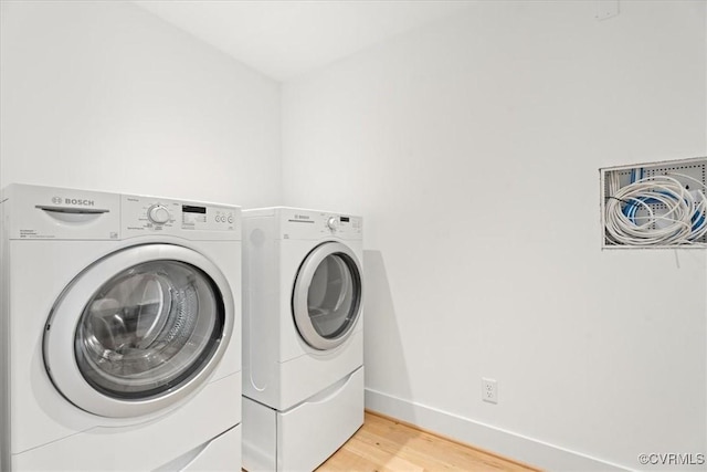 1665 Wilton Creek Rd, Hartfield, VA 23071 - washroom featuring separate washer and dryer, light wood-type flooring, and baseboards