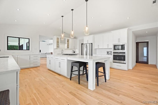 1665 Wilton Creek Rd, Hartfield, VA 23071 - kitchen with stainless steel appliances, light wood finished floors, white cabinetry, glass insert cabinets, and lofted ceiling