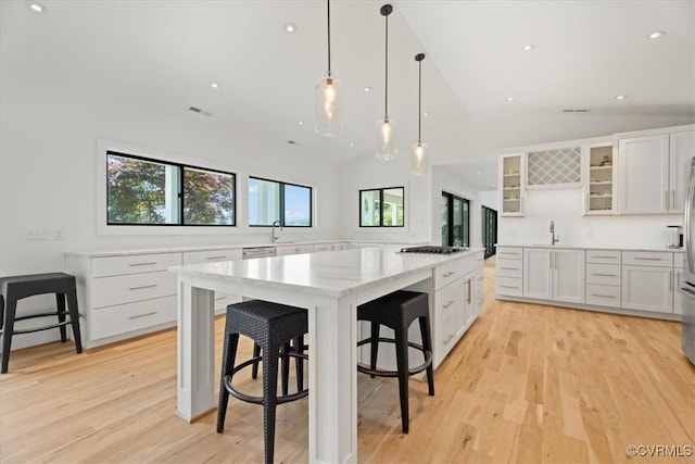 1665 Wilton Creek Rd, Hartfield, VA 23071 - kitchen with light wood-style floors, white cabinets, recessed lighting, gas cooktop, and glass insert cabinets