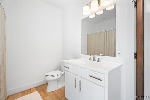 1665 Wilton Creek Rd, Hartfield, VA 23071 - full bath with vanity, toilet, wood finished floors, and baseboards