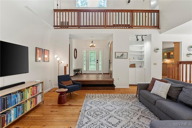 13700 Harbourwood Rd, Midlothian, VA 23112 - living room featuring wood finished floors, a towering ceiling, baseboards, and a chandelier