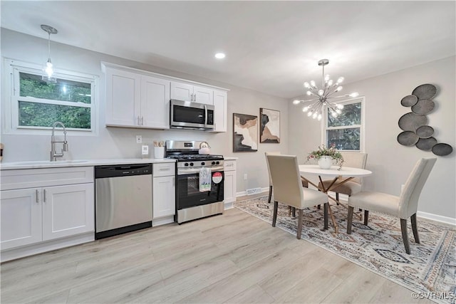 14 Gloucester Cir, Petersburg, VA 23803 - kitchen with appliances with stainless steel finishes, a chandelier, light wood-type flooring, pendant lighting, and light countertops