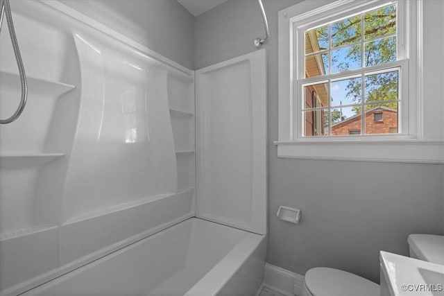 bathroom with baseboards, toilet, shower / bath combination, and vanity