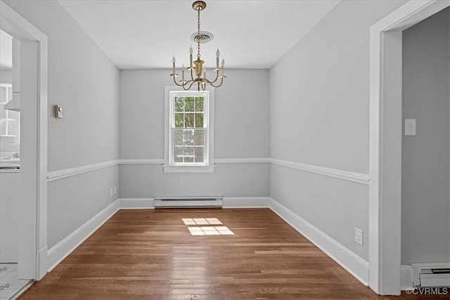 unfurnished dining area with baseboard heating, a chandelier, wood finished floors, and baseboards