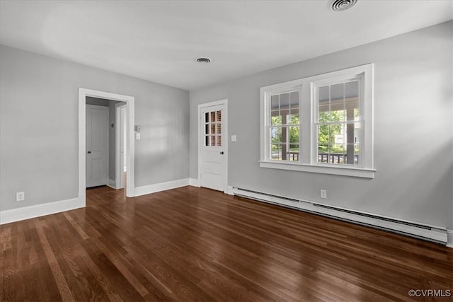 spare room with a baseboard heating unit, wood finished floors, and baseboards