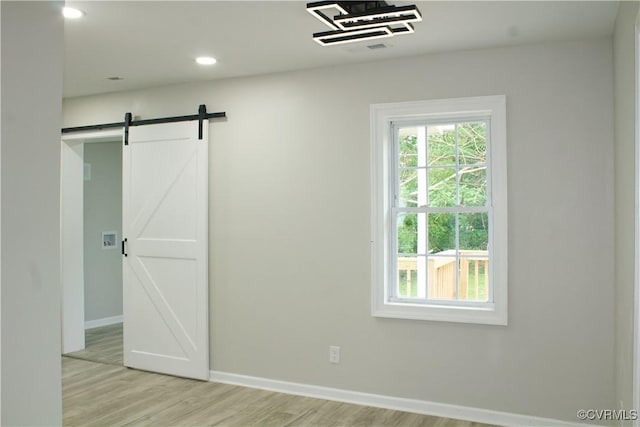 25 N Foley St, Petersburg, VA 23803 - unfurnished room with light wood finished floors, baseboards, a barn door, and recessed lighting