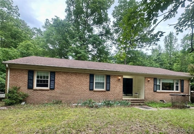 single story home featuring brick siding, a front lawn, and roof with shingles