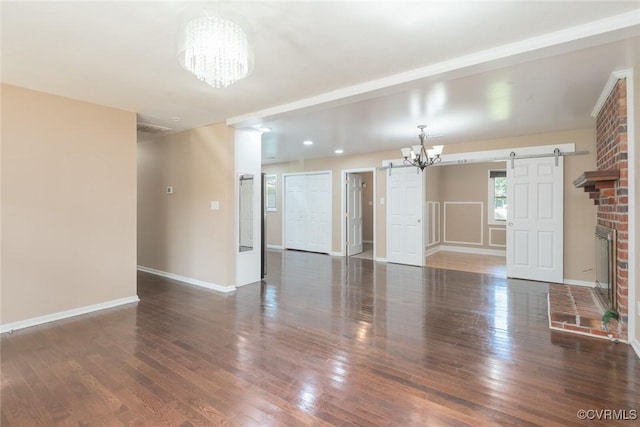 6006 Meadwood Cir, North Chesterfield, VA 23234 - unfurnished living room featuring a chandelier, a barn door, hardwood / wood-style flooring, and baseboards