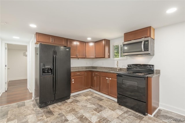 6006 Meadwood Cir, North Chesterfield, VA 23234 - kitchen with black appliances, a sink, brown cabinets, dark stone countertops, and baseboards