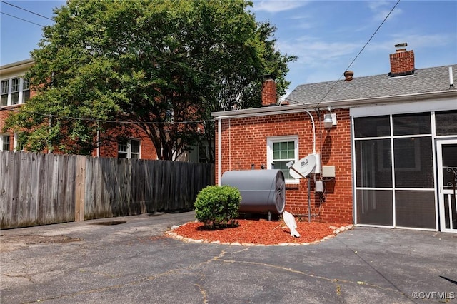 2405 Dumbarton Rd, Henrico, VA 23228 - view of property exterior featuring a chimney, brick siding, oil tank, and fence