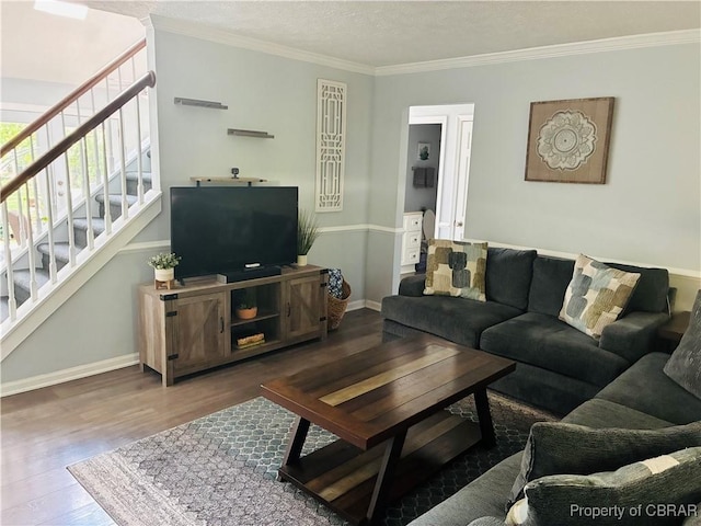 living area featuring wood finished floors, stairs, ornamental molding, baseboards, and a textured ceiling