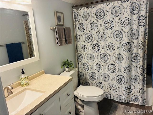 bathroom featuring toilet, vanity, a shower with shower curtain, and wood finished floors