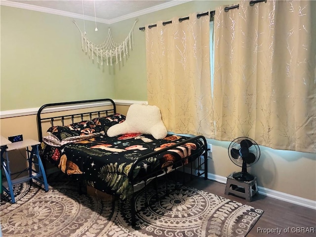 bedroom featuring baseboards, crown molding, and wood finished floors