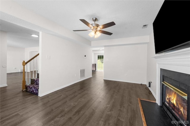 15119 Winding Ash Dr, Chesterfield, VA 23832 - unfurnished living room featuring a glass covered fireplace, dark wood-style floors, a ceiling fan, stairs, and baseboards