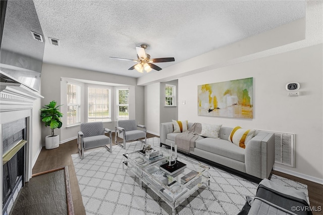 15119 Winding Ash Dr, Chesterfield, VA 23832 - living room with a fireplace, wood finished floors, a textured ceiling, baseboards, and ceiling fan