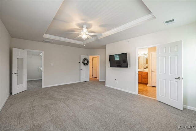 521 Siena Ln, Henrico, VA 23059 - unfurnished bedroom with a tray ceiling, light carpet, ornamental molding, a walk in closet, and ensuite bathroom