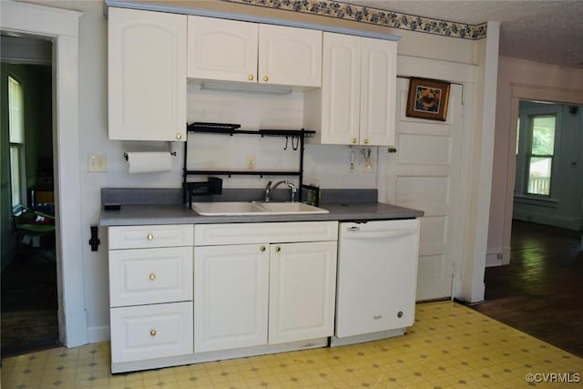 1006 N Main St, Farmville, VA 23901 - kitchen featuring white dishwasher, a sink, light floors, dark countertops, and white cabinets