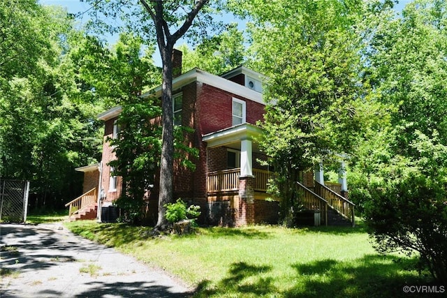 1006 N Main St, Farmville, VA 23901 - view of property exterior with a yard, brick siding, stairs, central air condition unit, and covered porch