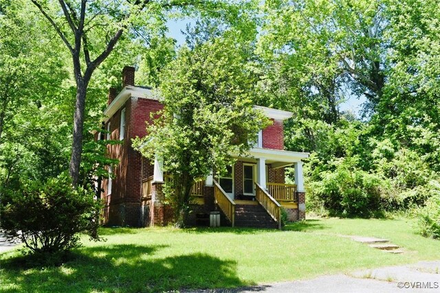 1006 N Main St, Farmville, VA 23901 - view of front of house featuring a chimney, brick siding, covered porch, and a front lawn