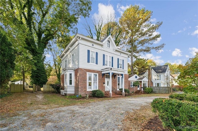 102 Market St, Onancock, VA 23417 - view of front of house with brick siding, fence, board and batten siding, and driveway