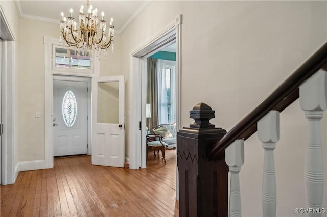 102 Market St, Onancock, VA 23417 - entrance foyer with crown molding, a chandelier, light wood-style flooring, and baseboards