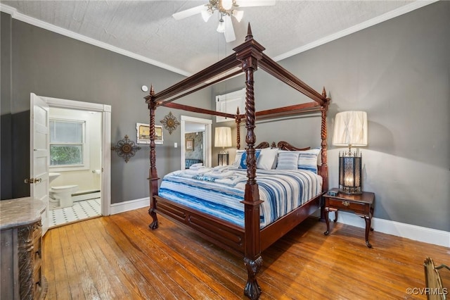 102 Market St, Onancock, VA 23417 - bedroom featuring baseboards, wood-type flooring, ensuite bath, baseboard heating, and ceiling fan