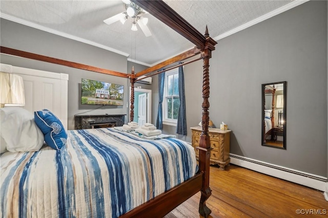 102 Market St, Onancock, VA 23417 - bedroom with wood finished floors, a baseboard heating unit, ornamental molding, and ceiling fan