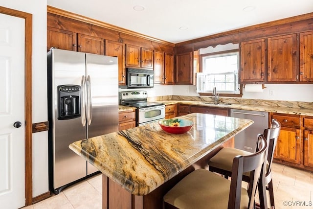 4800 Ball Cypress Rd, Chesterfield, VA 23832 - kitchen featuring stainless steel appliances, a sink, light tile patterned floors, a kitchen breakfast bar, and light stone countertops