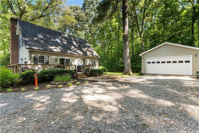 542 Cod Creek Dr, Heathsville, VA 22473 - view of front facade featuring a detached garage, an outdoor structure, a chimney, a deck, and roof with shingles
