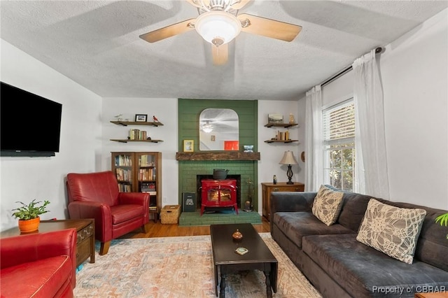 542 Cod Creek Dr, Heathsville, VA 22473 - living area featuring wood finished floors, a textured ceiling, ceiling fan, and a wood stove