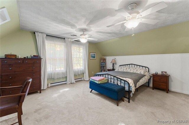542 Cod Creek Dr, Heathsville, VA 22473 - bedroom featuring vaulted ceiling, light carpet, baseboard heating, a ceiling fan, and wainscoting