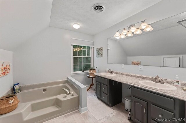 542 Cod Creek Dr, Heathsville, VA 22473 - full bathroom with lofted ceiling, a bath, double vanity, and wood finished floors