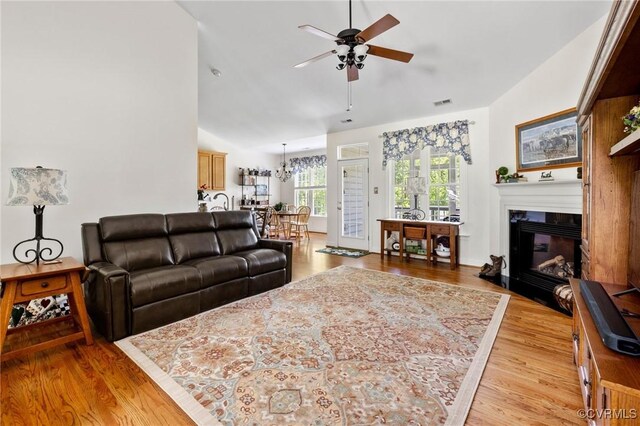 1629 Olmstead Dr, Powhatan, VA 23139 - living room featuring ceiling fan, light wood-style flooring, vaulted ceiling, and a glass covered fireplace
