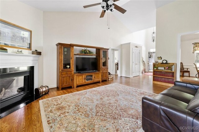 1629 Olmstead Dr, Powhatan, VA 23139 - living room featuring high vaulted ceiling, ceiling fan, wood finished floors, a glass covered fireplace, and baseboards