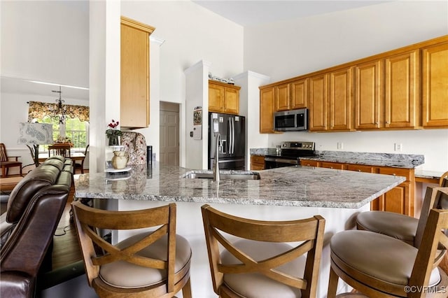 1629 Olmstead Dr, Powhatan, VA 23139 - kitchen with stainless steel appliances, a peninsula, high vaulted ceiling, a breakfast bar, and a sink