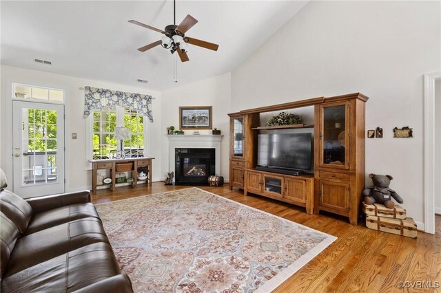 1629 Olmstead Dr, Powhatan, VA 23139 - living area with a ceiling fan, light wood-type flooring, a glass covered fireplace, high vaulted ceiling, and baseboards