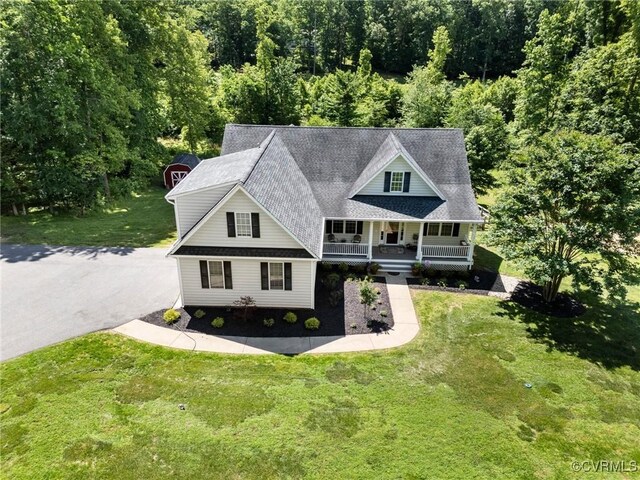 1629 Olmstead Dr, Powhatan, VA 23139 - view of front facade with covered porch, a front lawn, and a view of trees