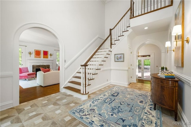 9001 Forest Ridge Ct, Henrico, VA 23229 - foyer with arched walkways, a high ceiling, stairway, a fireplace, and wood finished floors