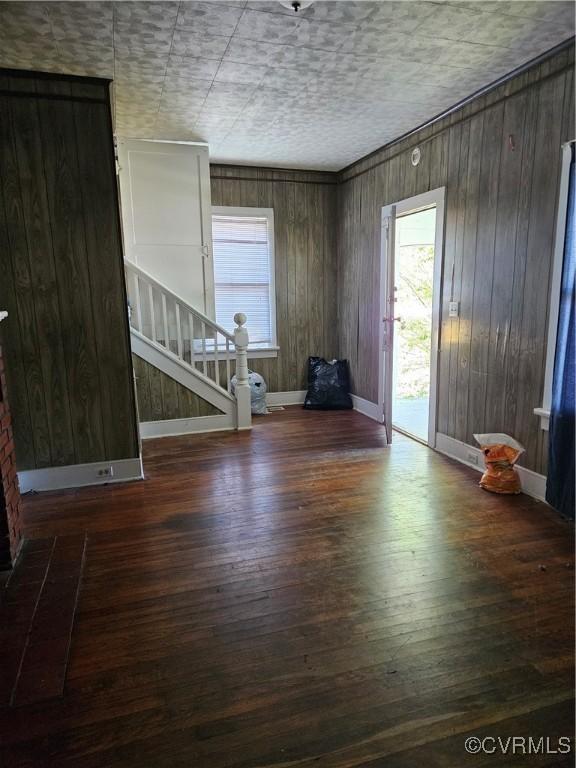 302 N High St, Blackstone, VA 23824 - spare room with healthy amount of natural light, wood finished floors, stairway, and wooden walls