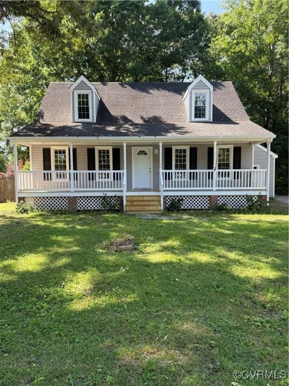 new england style home featuring covered porch and a front yard