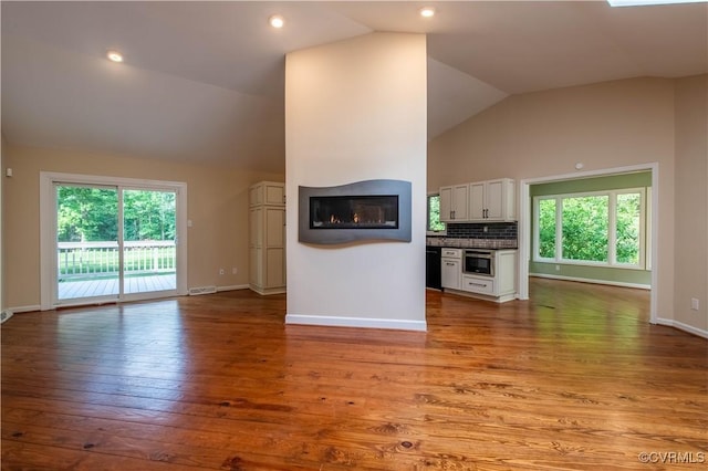 1396 Gray Fox Rd, Goochland, VA 23103 - unfurnished living room featuring vaulted ceiling, a glass covered fireplace, wood finished floors, and baseboards